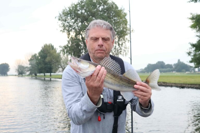 Richard vangt een snoekbaars vanuit de boot van visgids Fishmeister